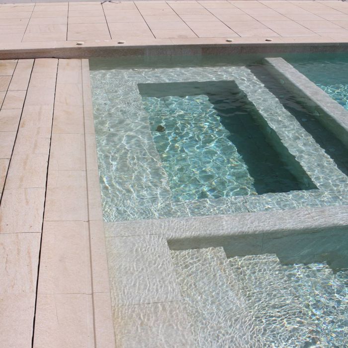 Spa construido en el interior de piscina con revestimiento porcelánico igual al de la piscina y la playa