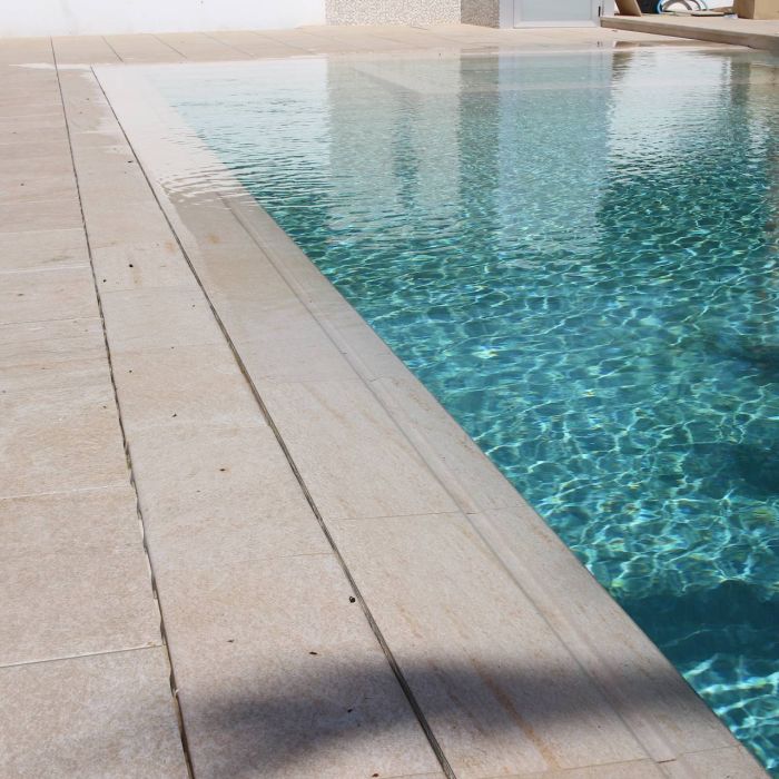 Piscina revestida con porcelánico Rosa Gres color beige que da al agua un color espectacular
