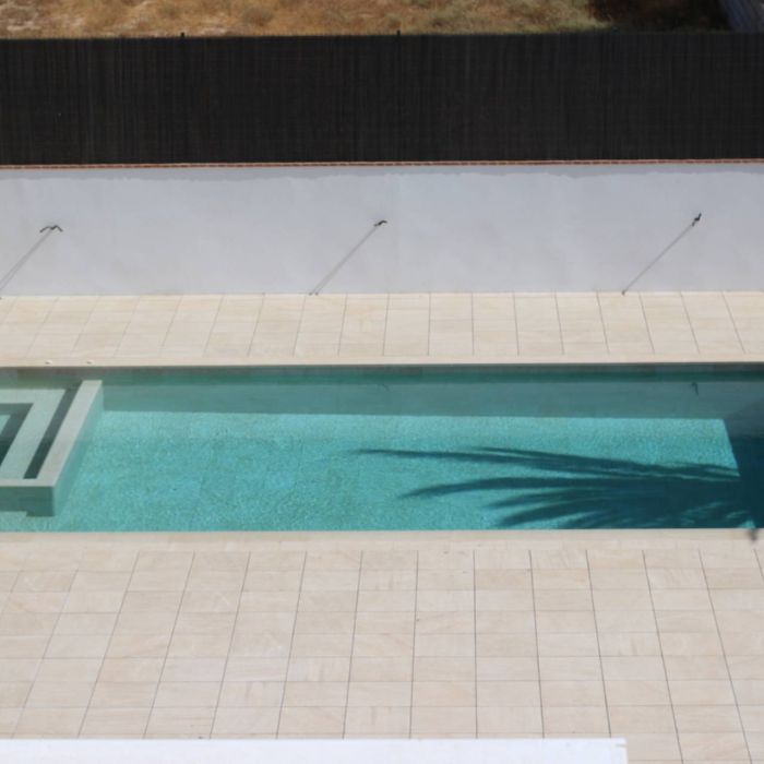 piscina desbordante alargada con spa integrado y persiana sumergida