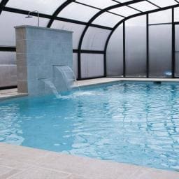 Piscina con cubierta elevada y cascadas decorativas y relax