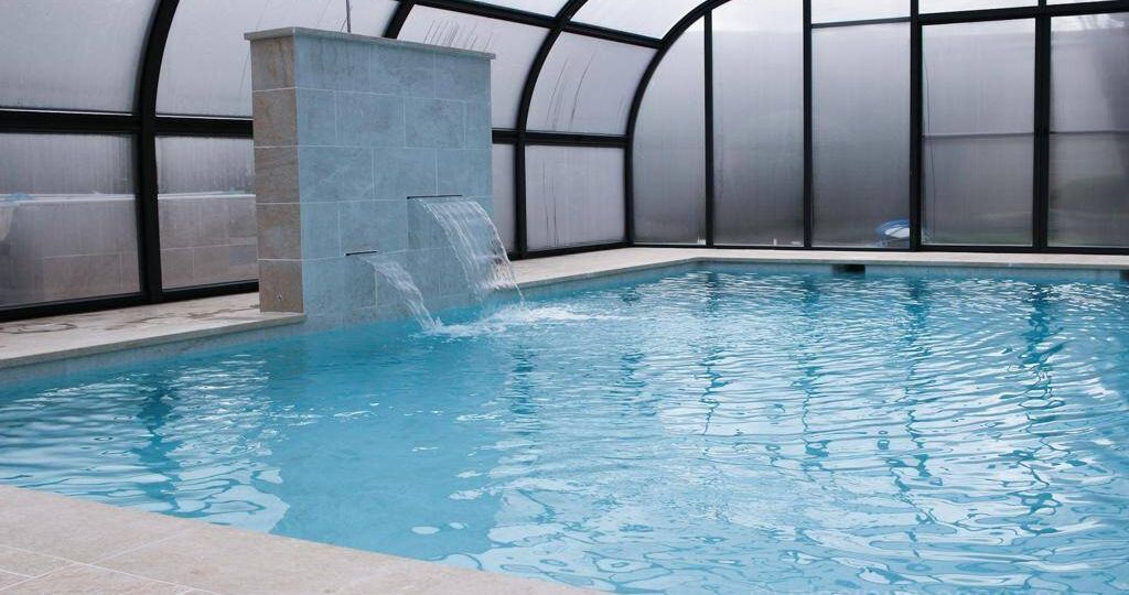 Piscina con cubierta elevada y cascadas decorativas y relax