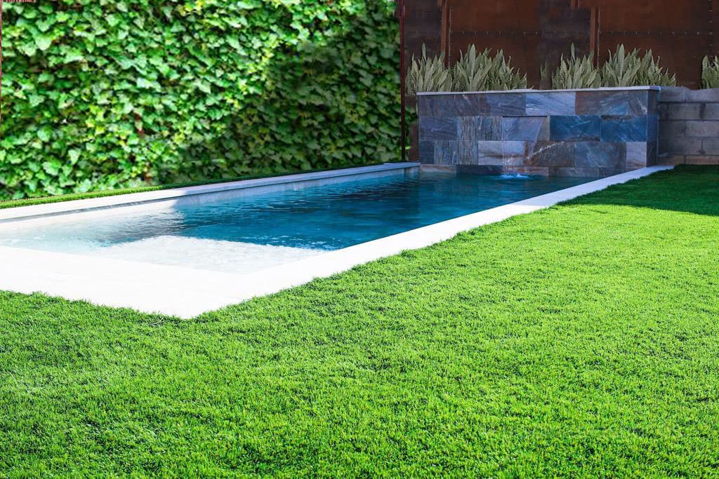Piscina de skimmers con cascada y porcelánico interior mix.