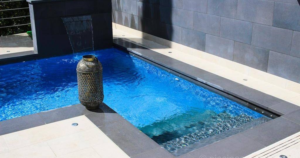 Escalera de obra fuera de la zona de baño de la piscina
