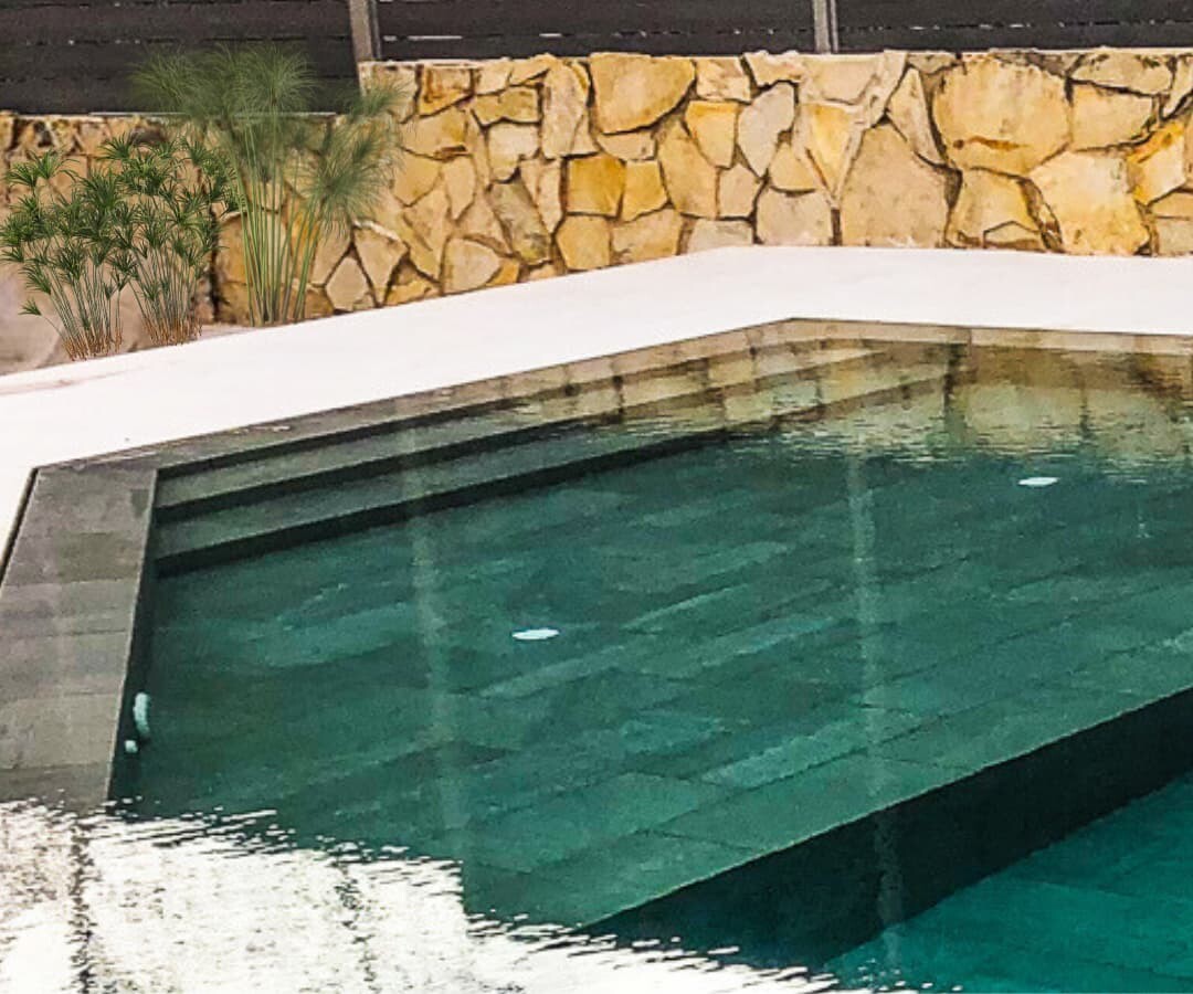 Escalera de obra en piscina porcelánica con zona poco profunda.