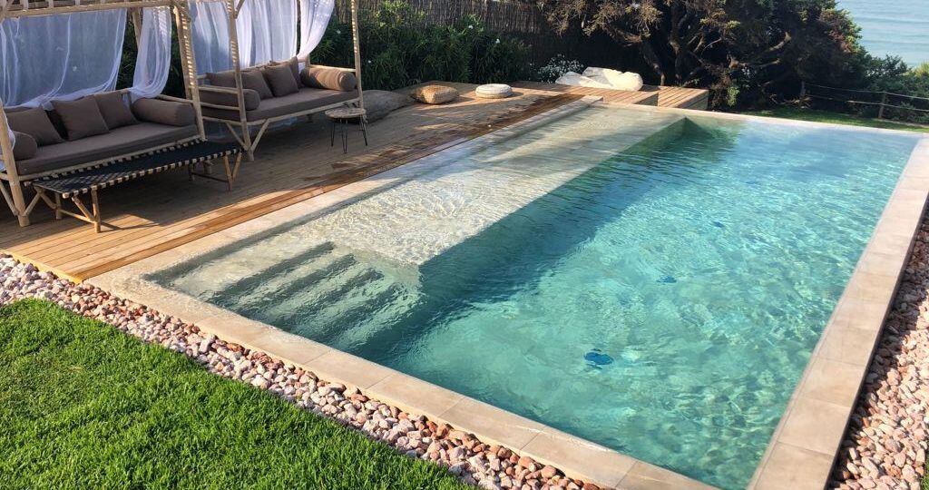 Escalera de obra porcelánica con cama de agua en el largo de la piscina