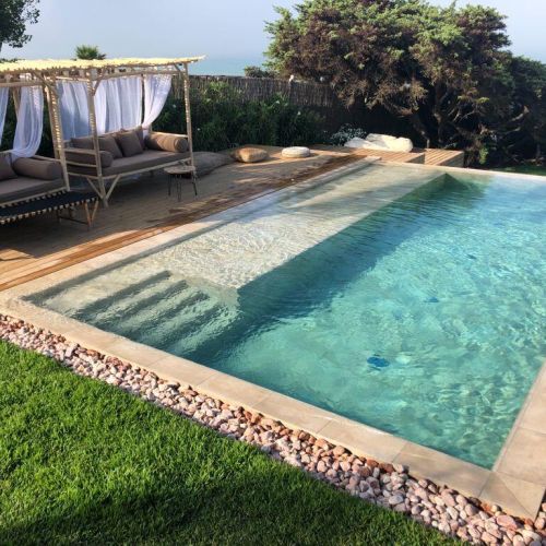 Escalera de obra porcelánica con cama de agua en el largo de la piscina con vistas al mar