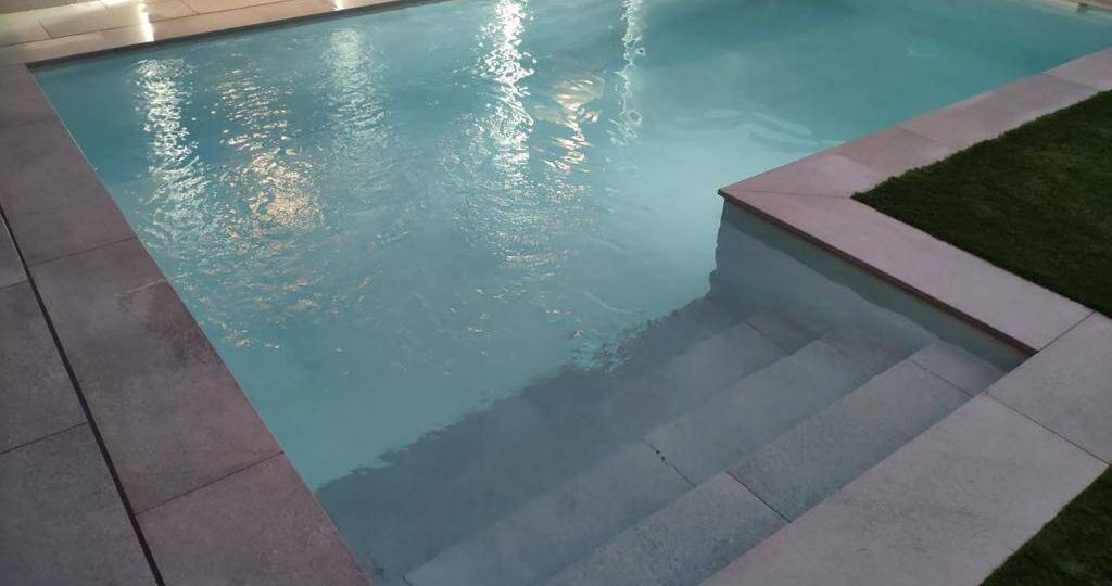 Piscina de obra con escalera fuera de la zona de baño en L