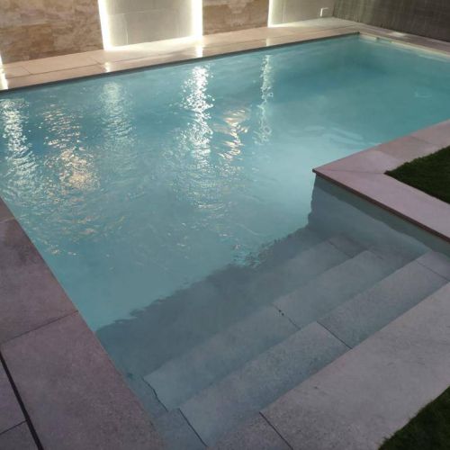 Piscina de obra con escalera fuera de la zona de baño en L