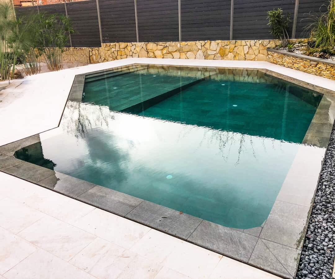 Piscina de obra reformada en jardín de Madrid