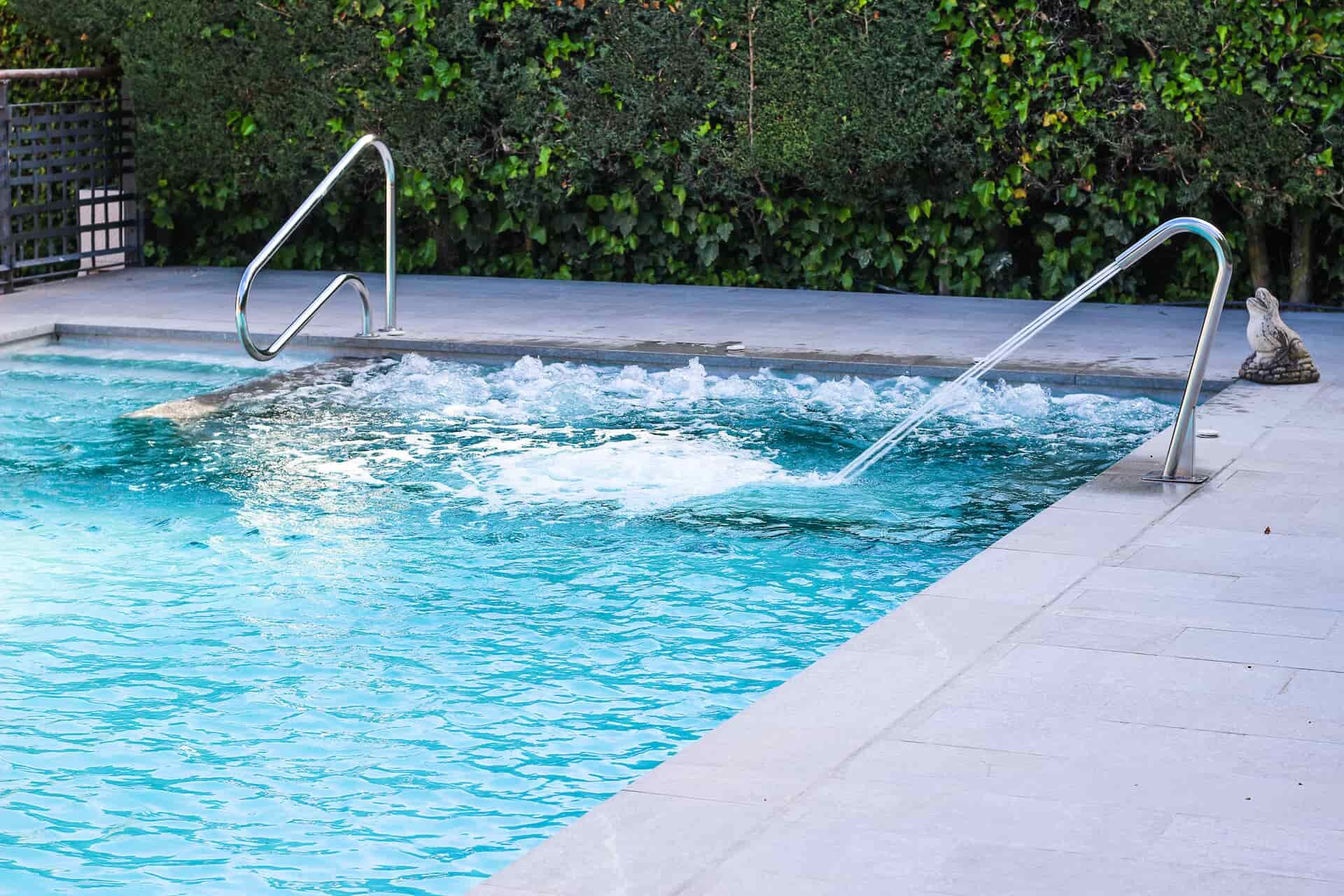 Pasamanos en piscina con jacuzzi interior y cascada cuello cisne